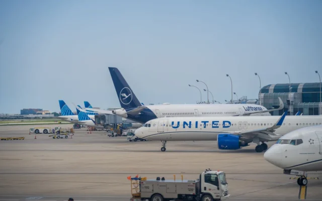 Avioane comerciale lângă terminalul unui aeroport și vehicule pentru serviciile la sol