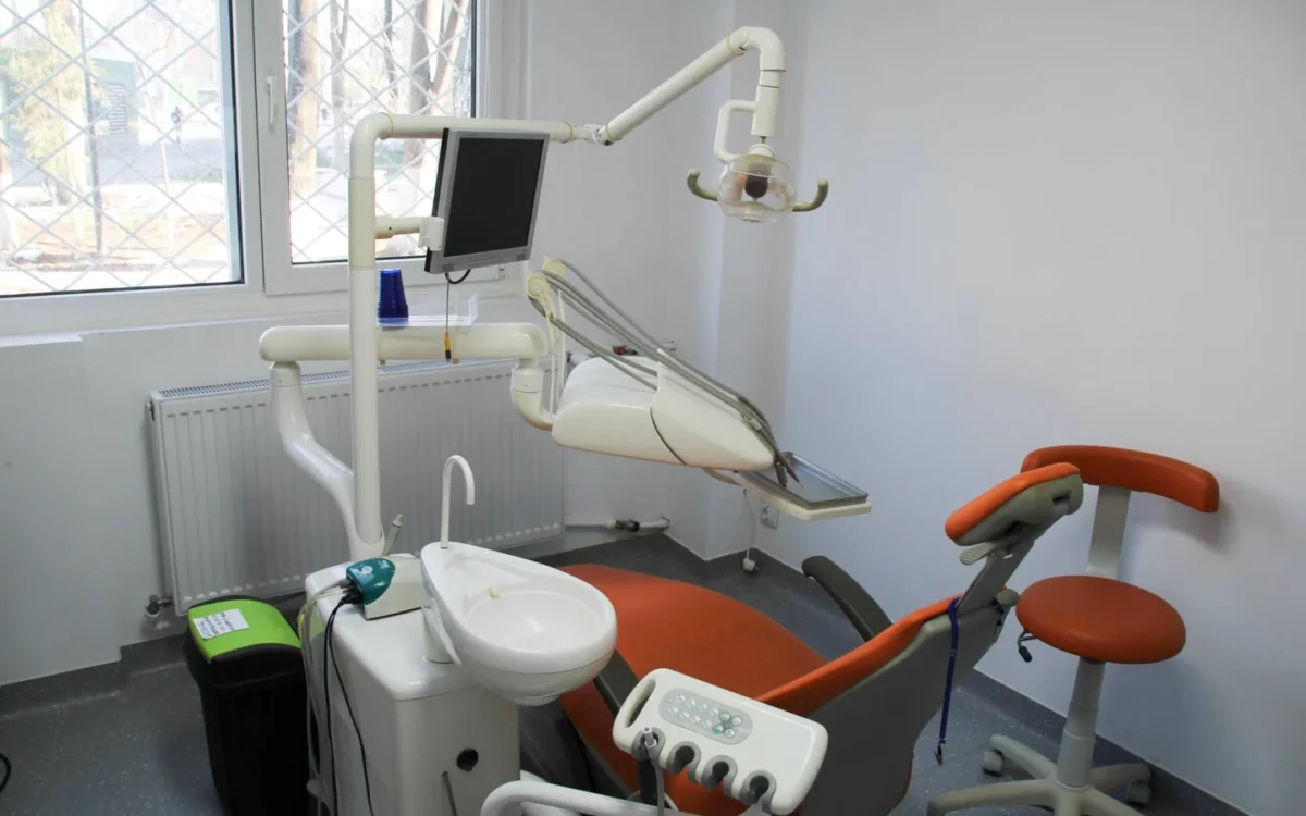Scaun stomatologic portocaliu, lampă și echipamente în cabinetul KIRILOVADENT