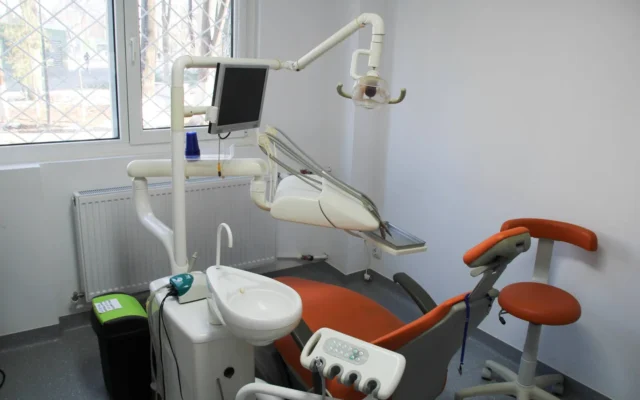 Scaun stomatologic portocaliu, lampă și echipamente în cabinetul KIRILOVADENT