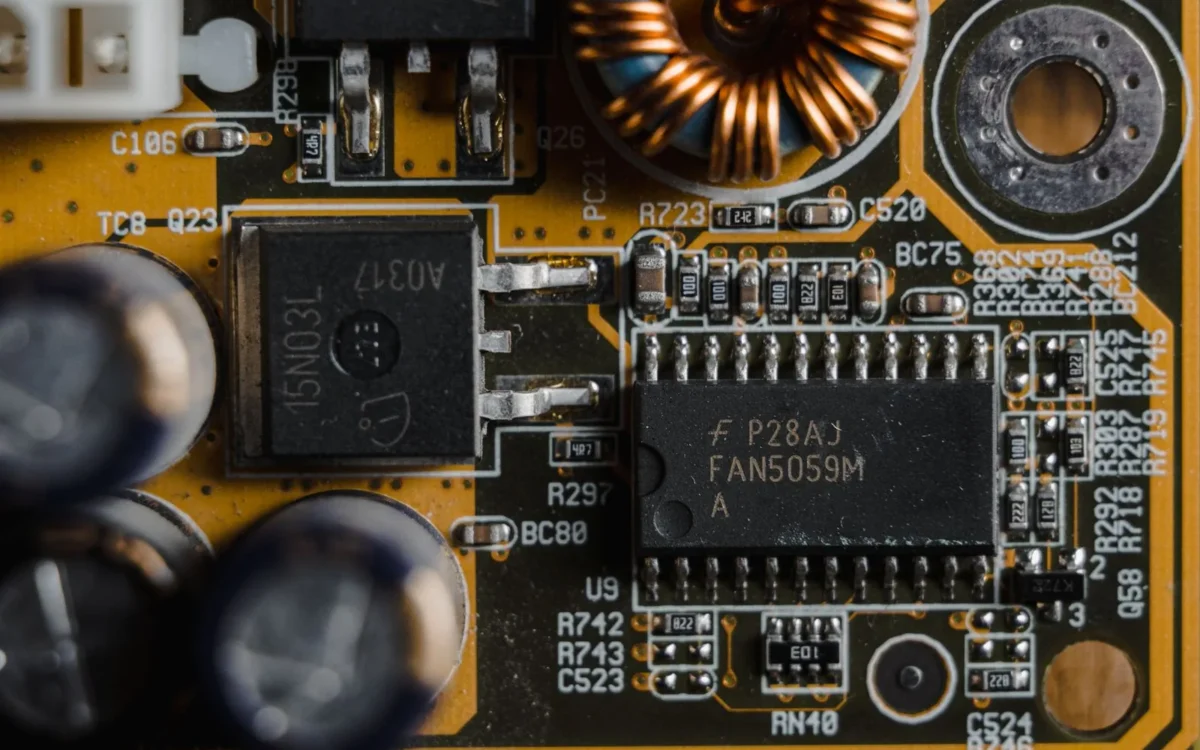 Microcipuri negre, condensatoare și bobină de cupru pe o placă electronică