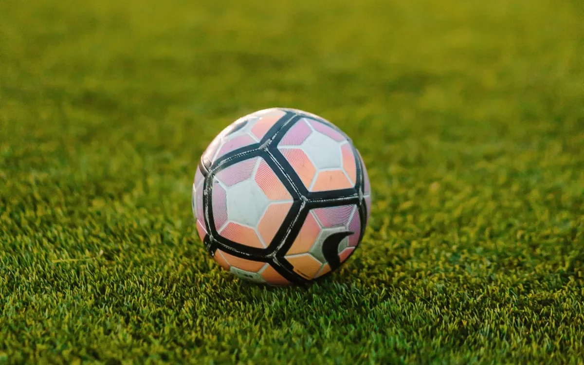 Minge de fotbal albă și roz pe gazon verde
