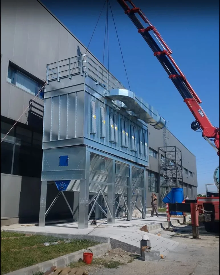 Instalație industrială de filtrare montată lângă o hală, cu o macara în apropiere