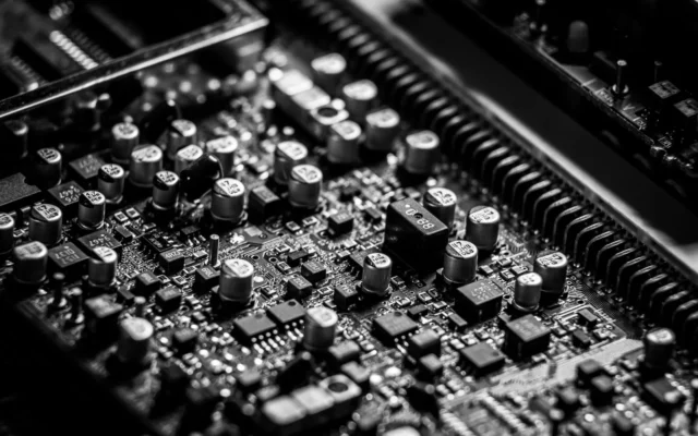 Microcipuri, condensatoare și conectori pe o placă electronică, în alb-negru