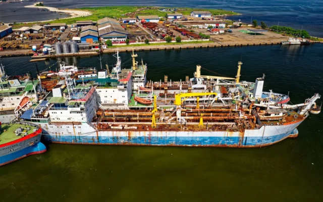 Nave acostate lângă cheiuri și depozite portuare, văzute de sus