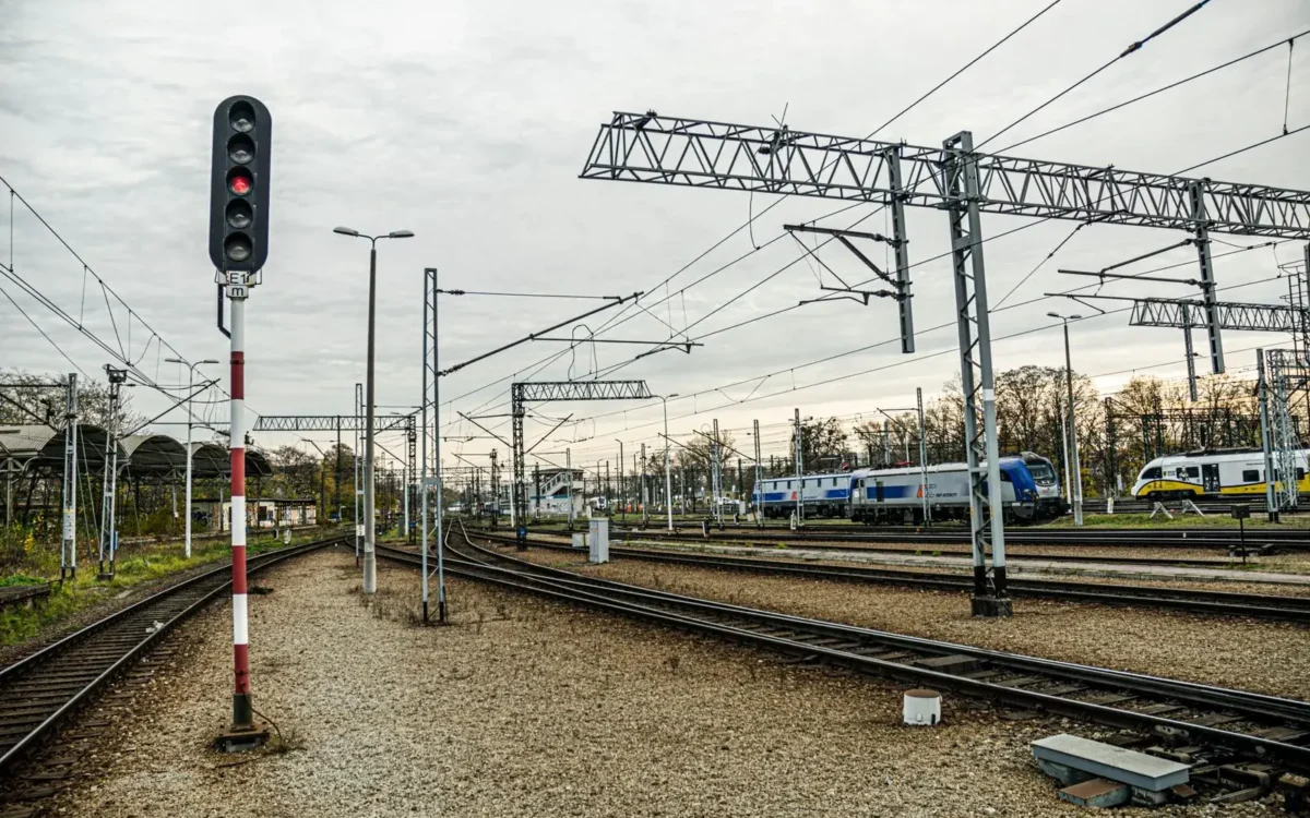 Linii de cale ferată electrificate, trenuri și semnale feroviare într-o gară
