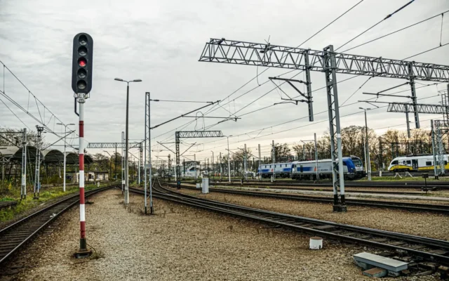 Linii de cale ferată electrificate, trenuri și semnale feroviare într-o gară