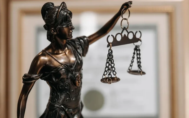 Statuetă a Justiției cu ochii acoperiți și balanță în mâna ridicată