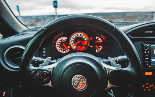 Volan și instrumente de bord fotografiate din interiorul unui autoturism.